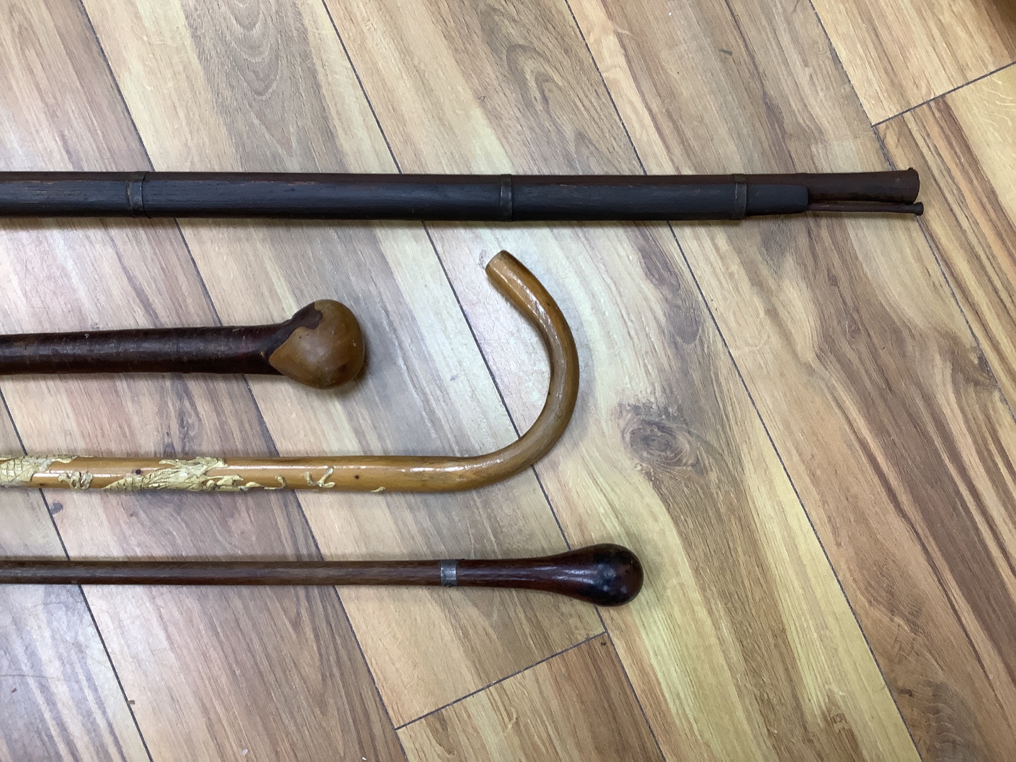 An Indian matchlock rifle and 3 walking sticks